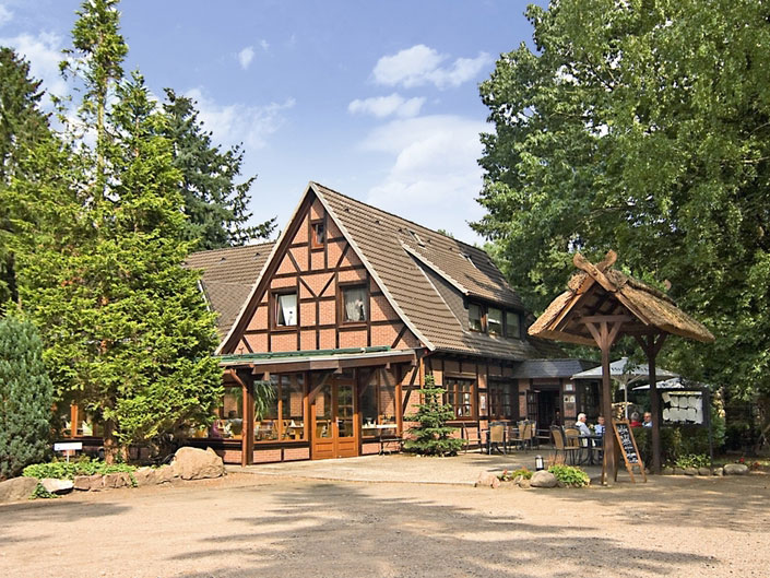 Sicht auf den Giebel des Fachwerkhauses umgeben von großen grünen Bäumen auf einem großen Waldgrundstück