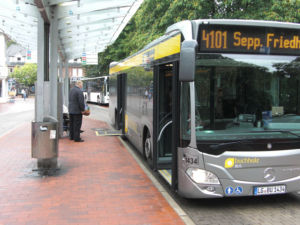 Ein Niederflurbus hält an einer Haltestelle mit ausgeklappter Rampe für Rollstuhlfahrer